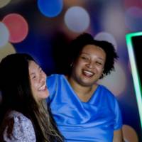 Two grads laugh taking photo at photo booth